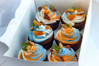 Lezzetli bir sürpriz yapmak için renkli kekleri olan bir hediye kutusu.