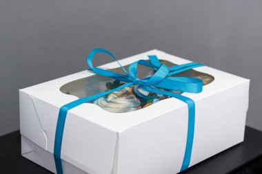 Lezzetli bir sürpriz yapmak için renkli kekleri olan bir hediye kutusu.