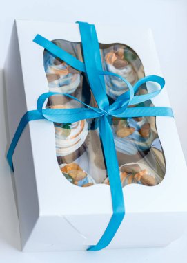 Lezzetli bir sürpriz yapmak için renkli kekleri olan bir hediye kutusu.