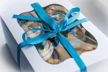 Lezzetli bir sürpriz yapmak için renkli kekleri olan bir hediye kutusu.