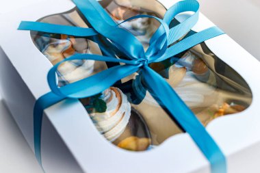 Lezzetli bir sürpriz yapmak için renkli kekleri olan bir hediye kutusu.