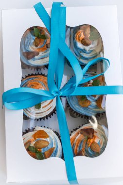 Lezzetli bir sürpriz yapmak için renkli kekleri olan bir hediye kutusu.