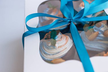 Lezzetli bir sürpriz yapmak için renkli kekleri olan bir hediye kutusu.