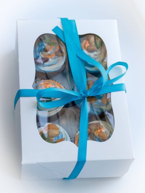 Lezzetli bir sürpriz yapmak için renkli kekleri olan bir hediye kutusu.