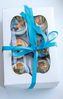 Lezzetli bir sürpriz yapmak için renkli kekleri olan bir hediye kutusu.