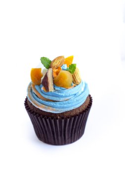 Beyaz arka planda naneli fındık ve meyvelerle süslenmiş güzel renkli kekler.