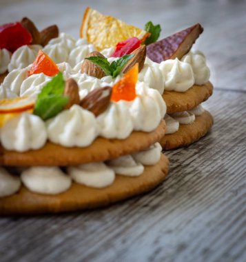 Beyaz dolgulu kremalı meyveli pasta, portakal cipsi, kurutulmuş meyve, naneyle süslenmiş.