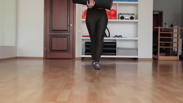 瑜伽课的准备过程 年轻快乐的女人在家里或工作室锻炼前滚动垫子 — 图库视频影像