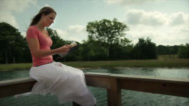 Kız yanında bir su birikintisi İncil okuma