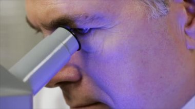 Laboratuar teknisyeni mikroskop mavi jel görünüyor