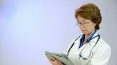 tablet PC'yi kullanma kadın doktor kameraya gülümsüyor