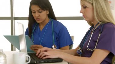 iki kadın hemşire notları a laptop içinde koyarak