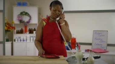 küçük işletme dükkanı sahibi bir telefon görüşmesi müşteriden alır.