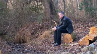 bir günlüğüne kaybettim düşüncelerini içinde orman üzerinde oturan adam