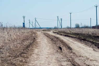 İlkbaharda Rusya 'da köyün kıyısındaki toprak yol.