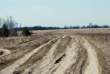 İlkbaharda Rusya 'da köyün kıyısındaki toprak yol.