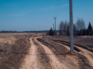 İlkbaharda Rusya 'da köyün kıyısındaki toprak yol.