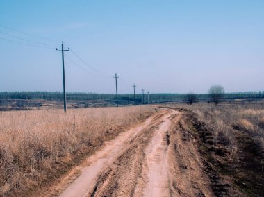 İlkbaharda Rusya 'da köyün kıyısındaki toprak yol.