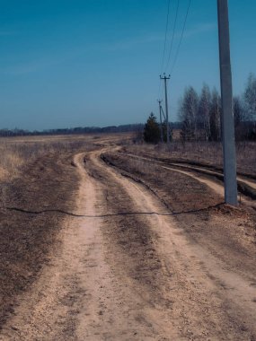 İlkbaharda Rusya 'da köyün kıyısındaki toprak yol.