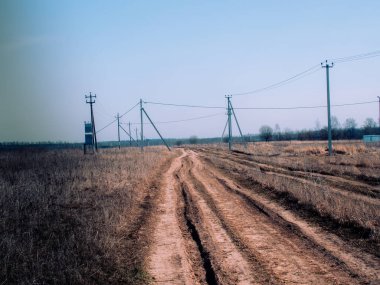 İlkbaharda Rusya 'da köyün kıyısındaki toprak yol.