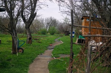 Baharda bulutlu bir günde bahçede bir patika.