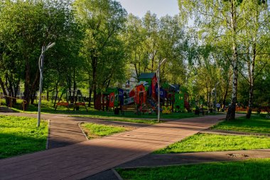 Sabahları, yazın parkın içinde asfalt yol var.