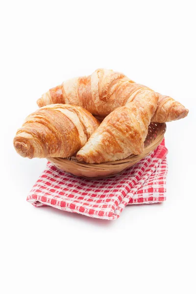 Fresh and tasty croissant on red checkered napkin — Stock Photo, Image