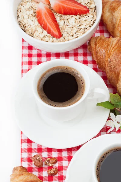 Coffee cup, croissant, oatmeal with strawberries and a sprig of — Stock Photo, Image