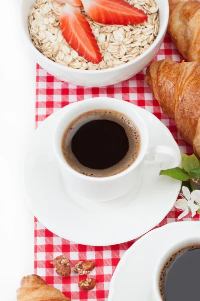  Kahve fincanı, kruvasan, çilek ile yulaf ezmesi ve sapı