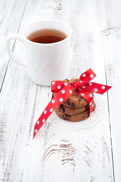 Galletas con chispas de chocolate en un plato blanco con taza de té —  Fotos de Stock