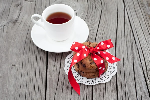 Chocolate chip cookies on a white plate with cup of tea — Stock Photo, Image