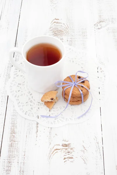 Soubory cookie na bílé desce s šálkem čaje Royalty Free Stock Fotografie