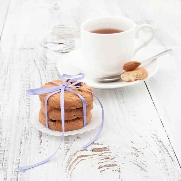 Biscuits aux pépites de chocolat sur une assiette blanche avec une tasse de thé — Photo