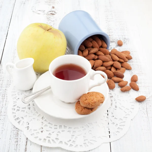 Ontbijt met huisgemaakte koekjes, apple en noten met kopje thee — Stockfoto