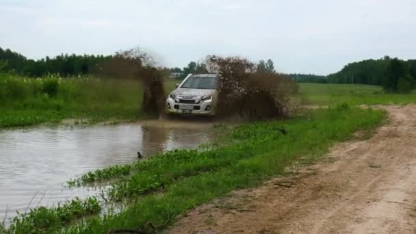 Camioneta pasa a través de un charco y barro con salpicaduras — Vídeos de Stock