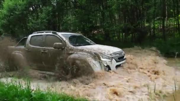 Pickup truk mengemudi melalui genangan lumpur dengan percikan — Stok Video