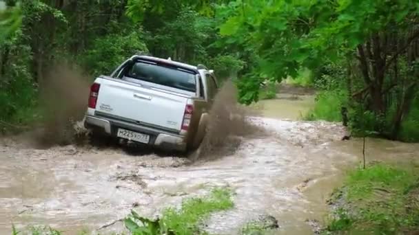 Camion pick-up guida attraverso una pozzanghera di fango con spruzzi e rimane bloccato alla fine — Video Stock