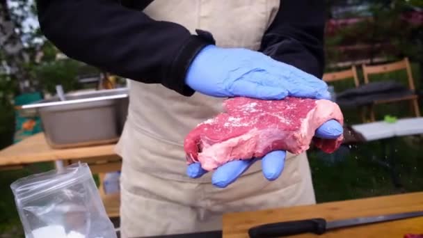 O sal é esfregado em um pedaço de carne fresca — Vídeo de Stock