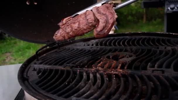 Sappige gebakken biefstuk wordt omgedraaid op een hete grill — Stockvideo