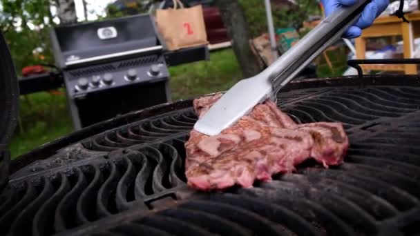 Juicy fried steak is turned over on a hot grill — Stock Video