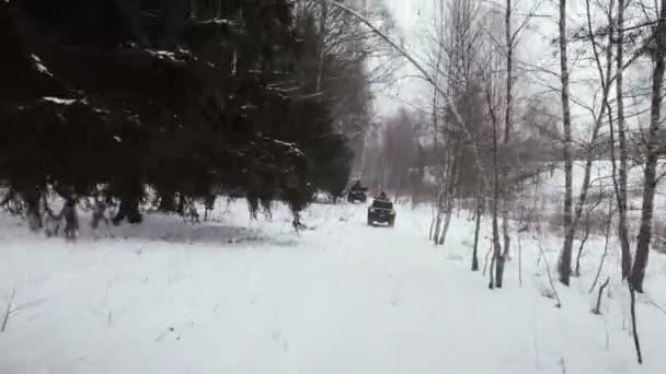 Πυροβολισμός από τετρακόπτερο. Ένας άντρας καβαλάει ένα ATV το χειμώνα. — Αρχείο Βίντεο