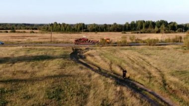 Siyah elbiseli, gözlüklü bir adam tek tekerleğe biniyor.