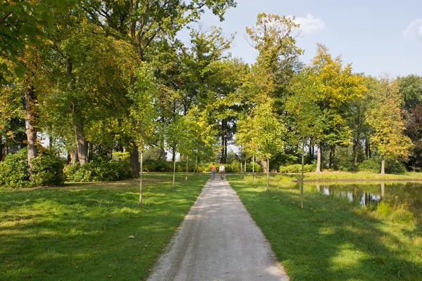 Hikers in garden of Castle De Cannenburgh with park pond, Netherlands — Stock Photo, Image