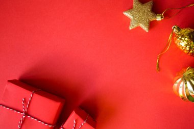 Noel hediyeleri paketlenmiş kırmızı kağıt. Altın toplar ve kutular. Yeni yıl düz görünümü arka planda yatıyordu. Şablon düzenleme tebrik kartı.