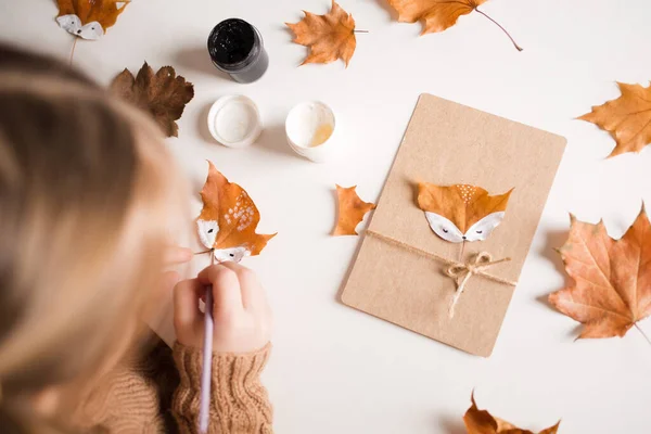 autumn craft for kids. animal Fox made from maple leaf. childrens art and creative. handicraft made from natural materials. girl draws with paints.