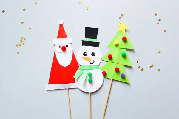 Çocuklar için kağıt işi. Kardan adam, Noel Baba ve mavi arka planda Noel ağacı. Çocuklar için sanat yaratmak. yeni yıl konsepti