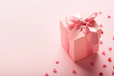 hediye ve küçük kalpler pembe arkaplanda kopyalama alanı ile.