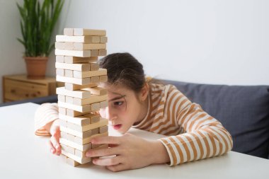 Çocuklar oyun hamuru oynuyorlar. Kızlar ahşap bloklardan bir kule inşa ederler, güzel motor becerileri geliştirme konsepti, ev yapımı oyunlar. Evde çocuklar için boş zaman aktiviteleri.