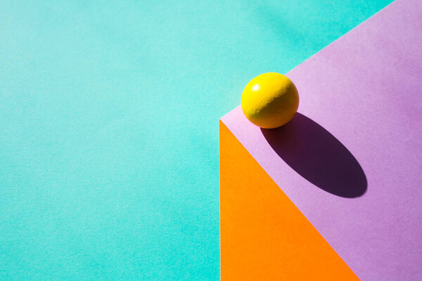 sheets of paper create illusion of three-dimensional cube. ball with hard shadow. geometric background in in bright colors