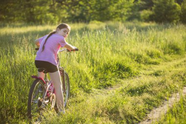 Yazın kırsalda bisiklet süren çocuk tatilde..